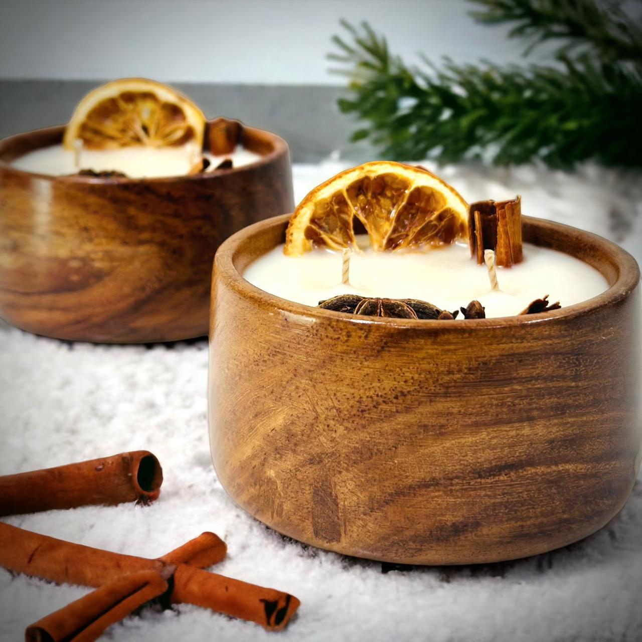 Studio Veeha signature candles in wooden bowls with dried orange and cinnamon